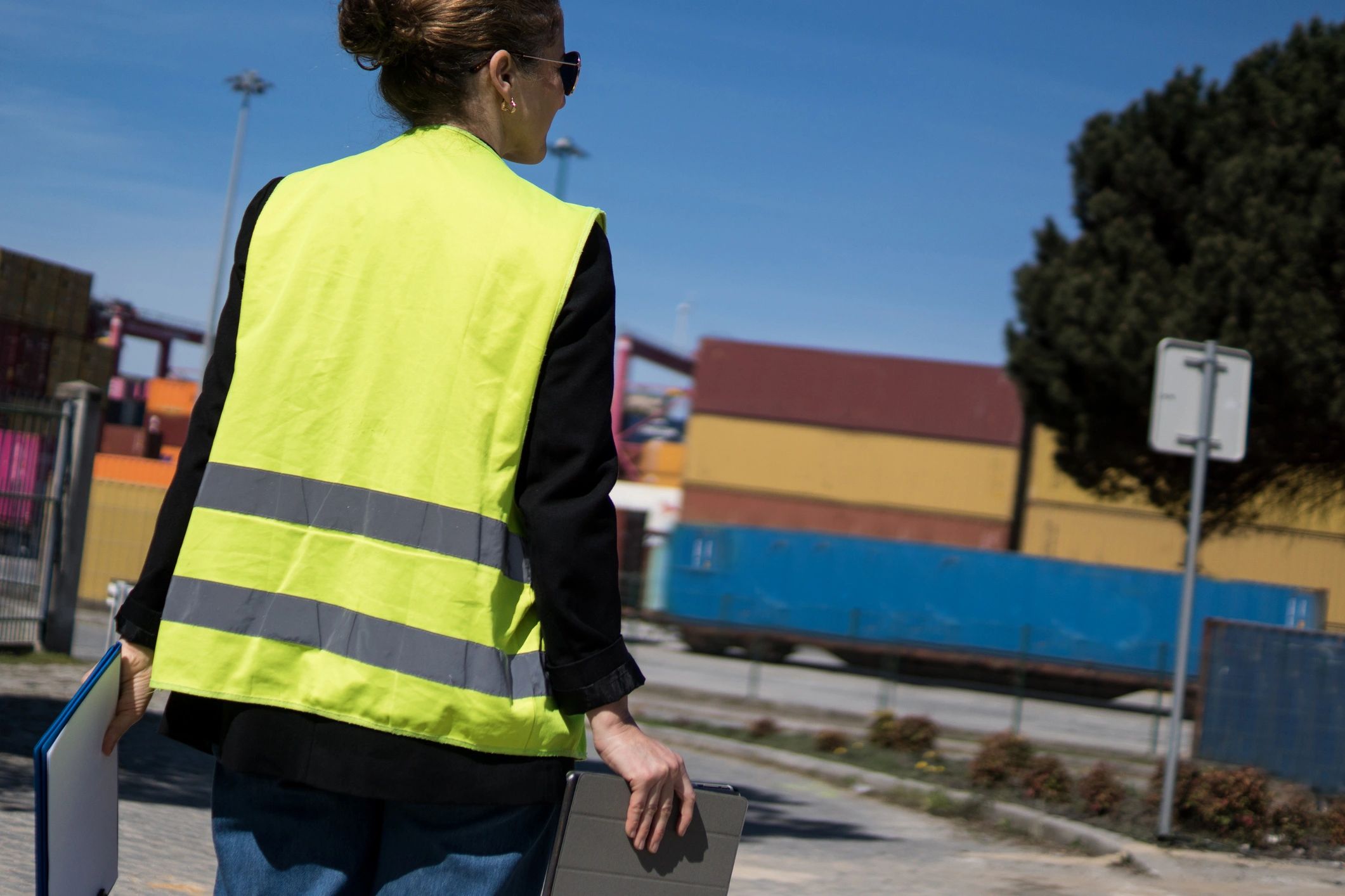 Logistics professional walking through a shipping terminal with a tablet